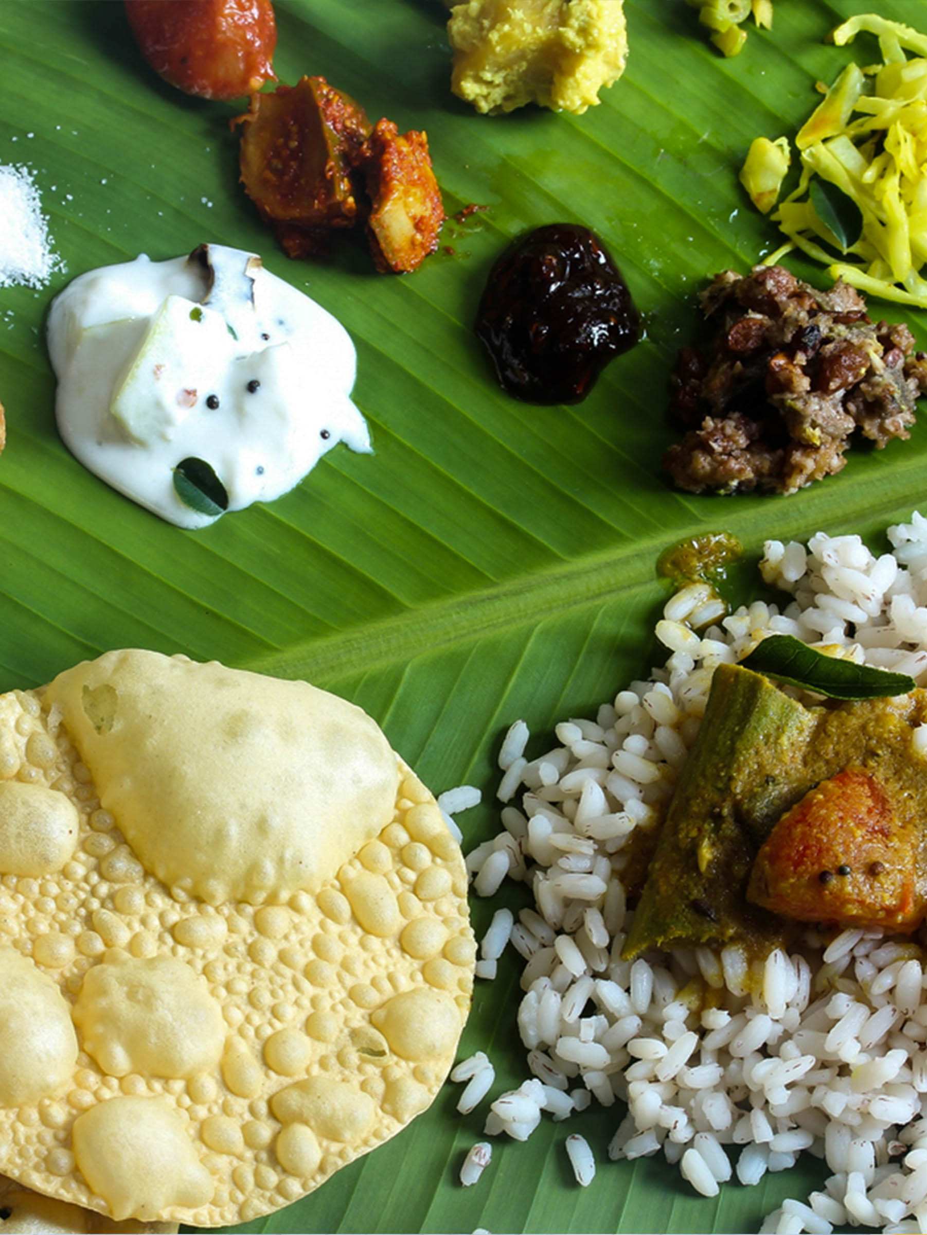 Close-up view of Jaffna special meals served on banana leaves, featuring traditional dishes such as spicy curries, rice, and side items, arranged in a visually appealing and authentic presentation.