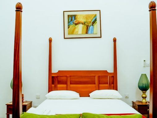The stylish and comfortable bed in the Lemon Grass Room at Flamingo Villa, Jaffna, featuring tasteful linens and inviting decor for a restful stay.