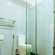 The contemporary bathroom in the Gloriosa Room at Flamingo Villa in Jaffna, featuring a spacious shower, a bidet, and elegant fixtures for a luxurious experience.